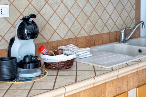 a kitchen counter with a sink and a basket of dishes at Albachiara Sul Mare in Porto Torres