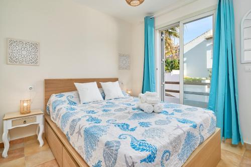 a bedroom with a bed with a blue and white comforter at La Casita Azul in Almuñécar