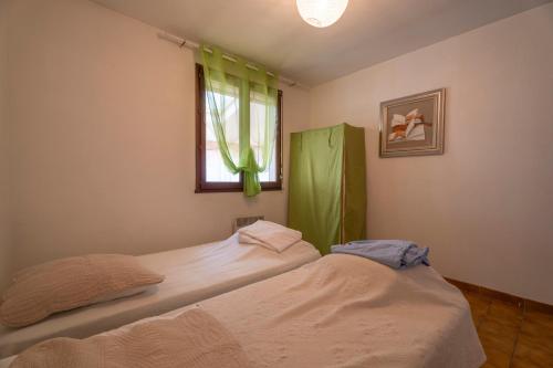 two twin beds in a room with a window at Villa Arbre de Vie in La Crau
