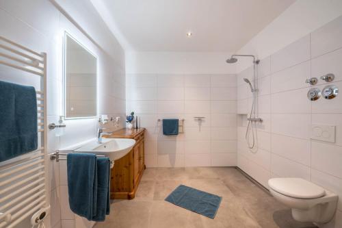 a white bathroom with a sink and a toilet at Ferienwohnung Max in Gilching