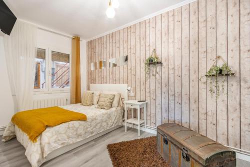 a bedroom with a bed and a wooden wall at Casa pablo y francisca in Alfarrás