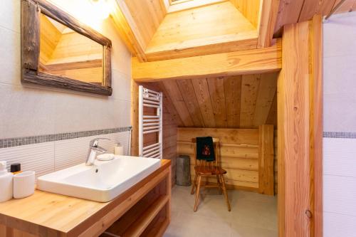 a bathroom with a sink and a wooden ceiling at Chalet Le Chastel in Pelvoux