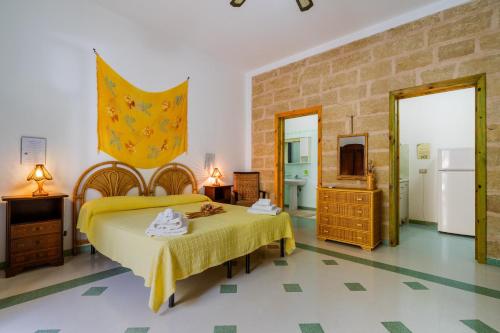 a bedroom with a bed with a yellow bedspread at Domus mea salento Arazzo Giallo in Ugento
