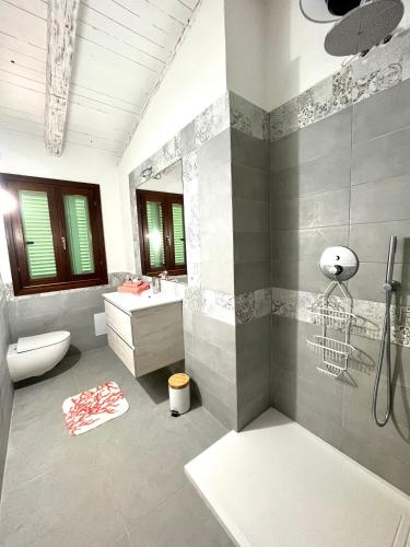 a bathroom with a sink and a toilet and a mirror at Villa Alzoni in San Teodoro