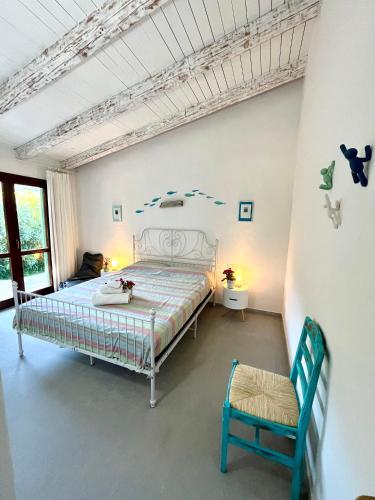 a bedroom with a bed and a chair at Villa Alzoni in San Teodoro