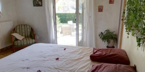 a bedroom with a bed and a door to a patio at Chambre D'hôtes La Grande Calade in Lagrand