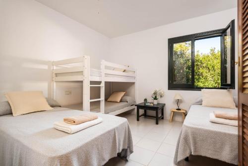 a bedroom with two beds and a bunk bed at Villa Es Gallinots in Mahón