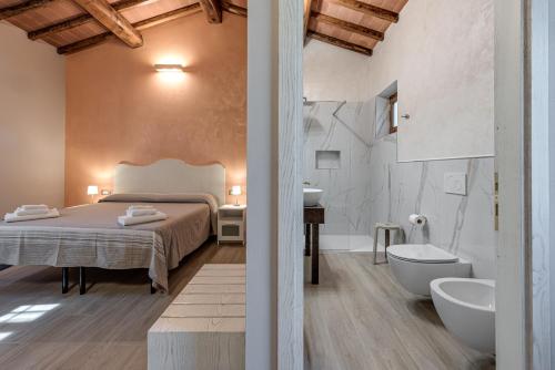 a bedroom with a bed and a tub and a sink at Il Borghetto Bed and Breakfast in Borgo San Lorenzo