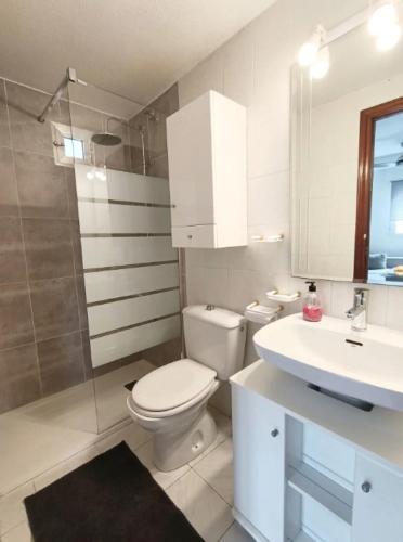 a white bathroom with a toilet and a sink at R-06 Holiday Apartment La Mata in La Mata