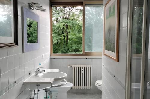 a bathroom with a sink and a toilet and a window at Residenza sul Livenza in Sacile