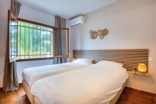 two beds in a room with a window at Villa Pura Vida by Easy Brava in Calonge