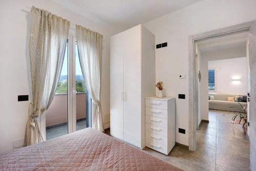 a bedroom with a bed and a dresser with a window at Antichi Ricordi - Il Nido in Marina di Andora