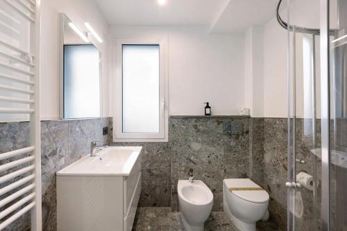 a white bathroom with a toilet and a sink at Antichi Ricordi - Il Nido in Marina di Andora