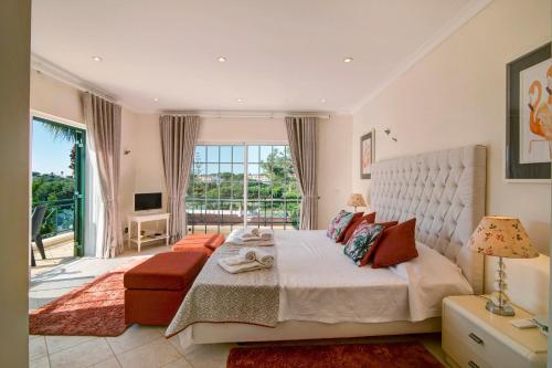 a bedroom with a large bed and a large window at Casa Valerie in Vale do Lobo