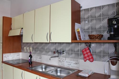 a kitchen with white cabinets and a sink at Vista Lago Casa Demonti in Tignale