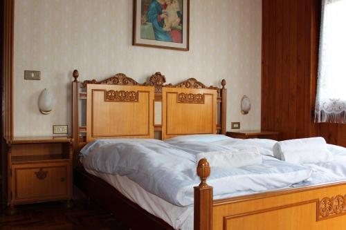 a bedroom with a large bed with white sheets at Vista Lago Casa Demonti in Tignale