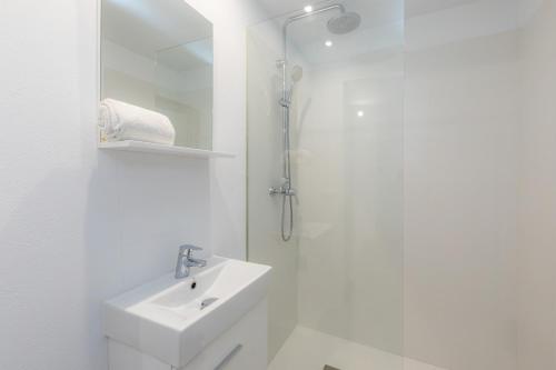 a white bathroom with a sink and a shower at Casa Coronel Aloy in Pollença