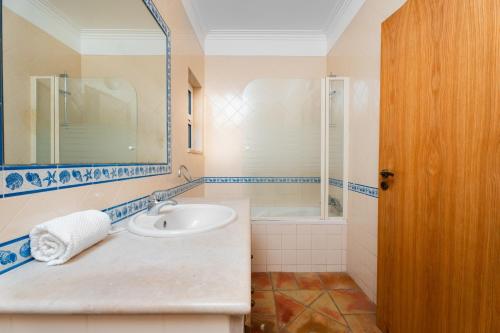 a bathroom with a sink and a mirror and a tub at Villa Las Rosas in Albufeira