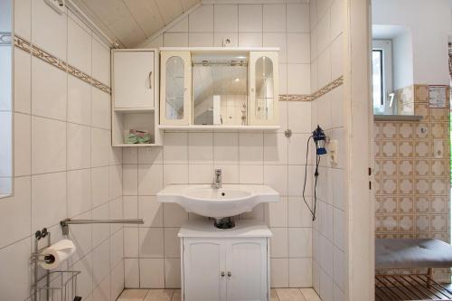 a white bathroom with a sink and a shower at Haus Gerda in Stadum