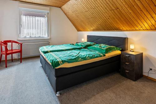 a bedroom with a bed and a red chair at Eule in Donaueschingen