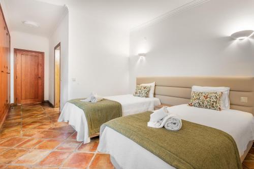 a room with two beds with towels on them at Villa Las Rosas in Albufeira