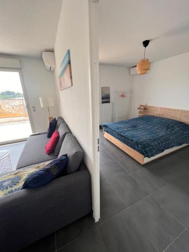 a living room with a couch and a bed at Appartement T2 Muses in Le Crès