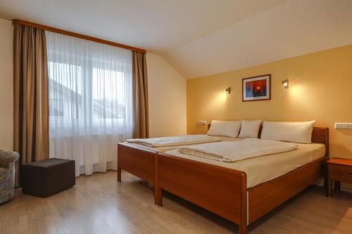a bedroom with a large bed with a large window at Ferienwohnung Irmi in Hergensweiler