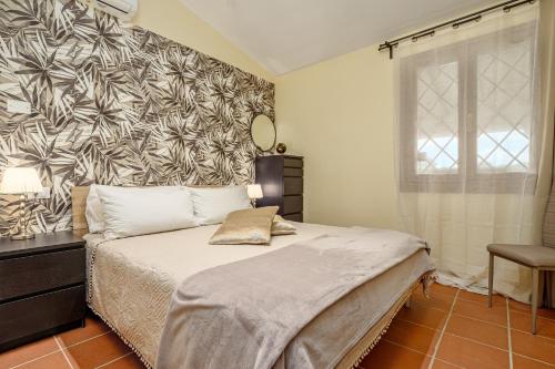 a bedroom with a large bed with a black and white wallpaper at Villa Caterina in Punta Molara