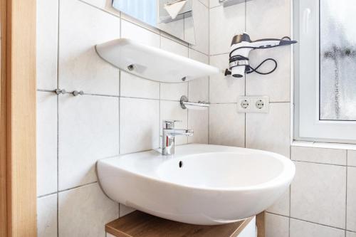 a white bathroom with a sink and a window at Ferienhaus Lütt-Matten in Ostseebad Sellin