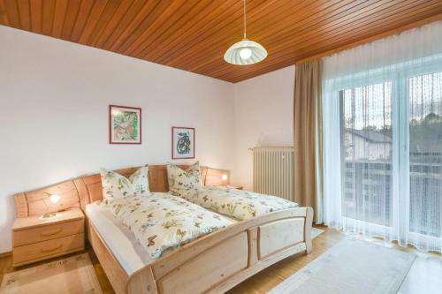 a bedroom with a bed and a large window at Ferienwohnung Wennesz 1 in Chieming