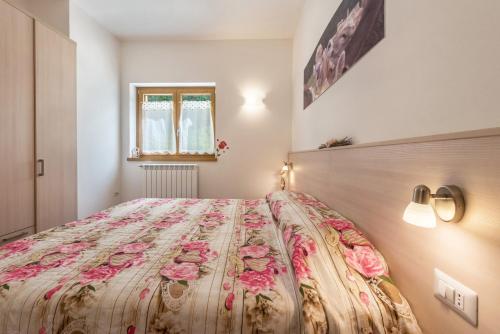 a bedroom with a large bed with a floral bedspread at Nonno Bigi Rosa in Tremosine Sul Garda