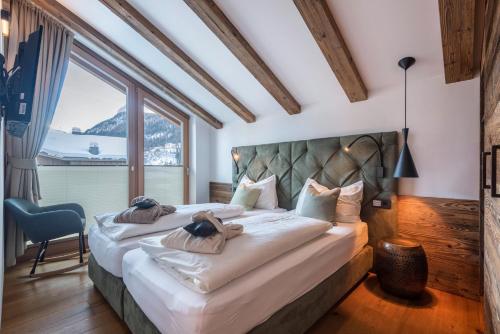a bedroom with a large bed with a large window at Paruda Mountainchalet in Ortisei