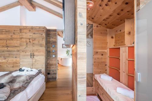 a bedroom with wooden walls and a bed in a room at Paruda Mountainchalet in Ortisei