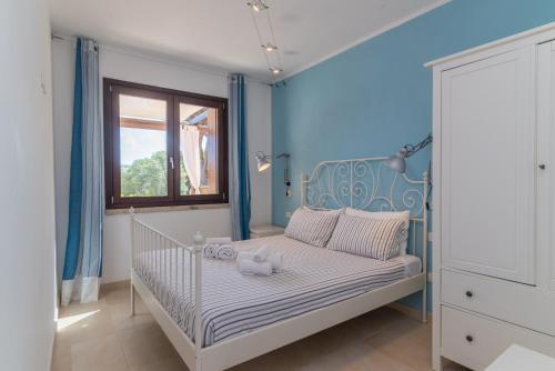 a bedroom with a crib with a blue wall at C 102 Puntavilla Mare in La Maddalena