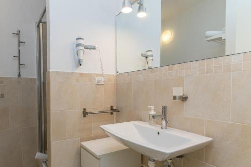 a bathroom with a sink and a mirror at C 102 Puntavilla Mare in La Maddalena