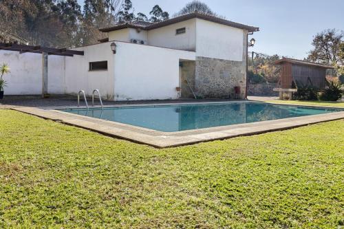 a swimming pool in front of a house at Quinta Da Ataíde in Rendufe