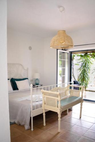 a bedroom with a bed and a table and a chandelier at Casa do Vagar in Vimieiro