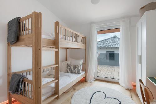 ein Schlafzimmer mit Etagenbetten und einem Balkon in der Unterkunft Bayerwald Refugium in Schwarzach