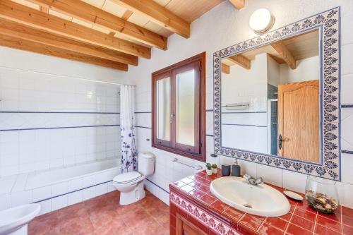 a bathroom with a sink and a toilet and a mirror at Finca Sa Pova in Alcudia