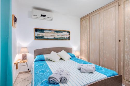 a bedroom with a blue bed with towels on it at 5 Appartamento Isuledda in San Teodoro