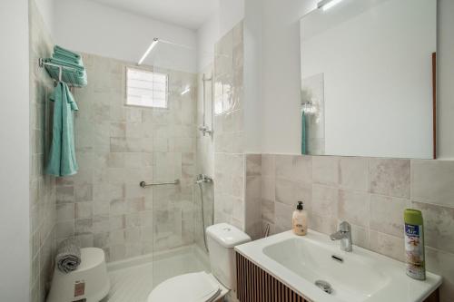 a bathroom with a sink and a toilet and a mirror at Apartamento Danoe 5 in Mogán