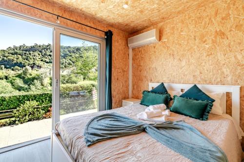 a bedroom with a bed with a large window at Quintinha Da Aldida - Gerês in Vieira do Minho