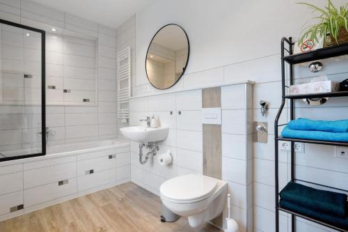 a bathroom with a toilet and a sink and a mirror at Ferienwohung Finsterwalde in Finsterwalde