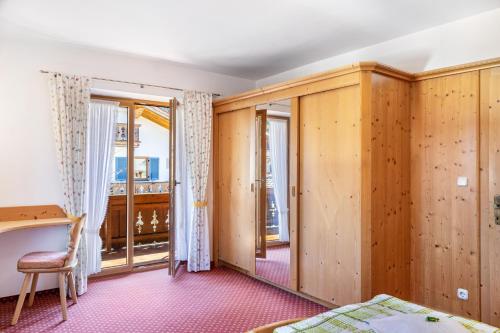 a room with wooden walls and a bed and a window at Alpenblick Tilly - Fewo Soiernsee 4 in Krün