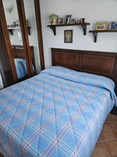 a bed with a blue comforter in a bedroom at Trilocale a Santa Maria Maggiore in Santa Maria Maggiore