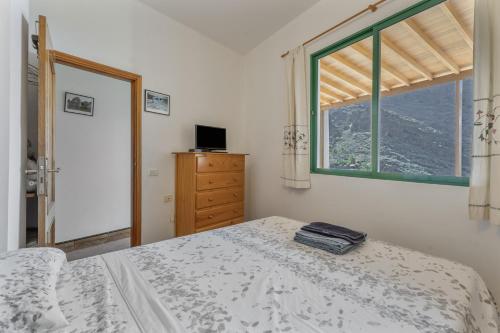 a white bedroom with a bed and a window at Apartamento Nayara A in Calera
