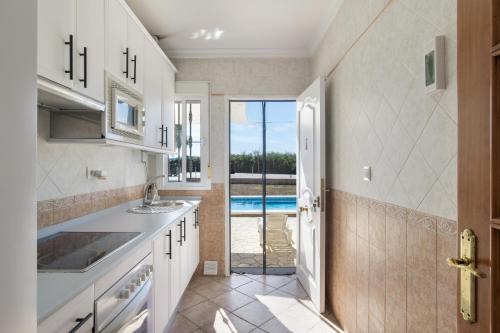 a kitchen with a sink and a door to a pool at Chalet Independiete Con Piscina in Cádiz