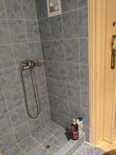 eine Dusche in einem Badezimmer mit grauen Fliesen in der Unterkunft Pylos before midnight in Pylos