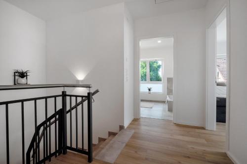 a hallway with white walls and a staircase in a house at Das Strandhaus am Dümmer See in Lembruch
