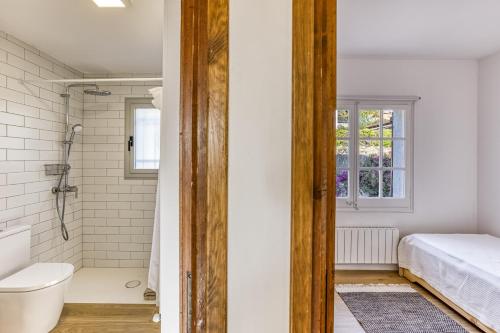 a bathroom with a shower and a toilet and a sink at Villa Les Aulines in Calonge